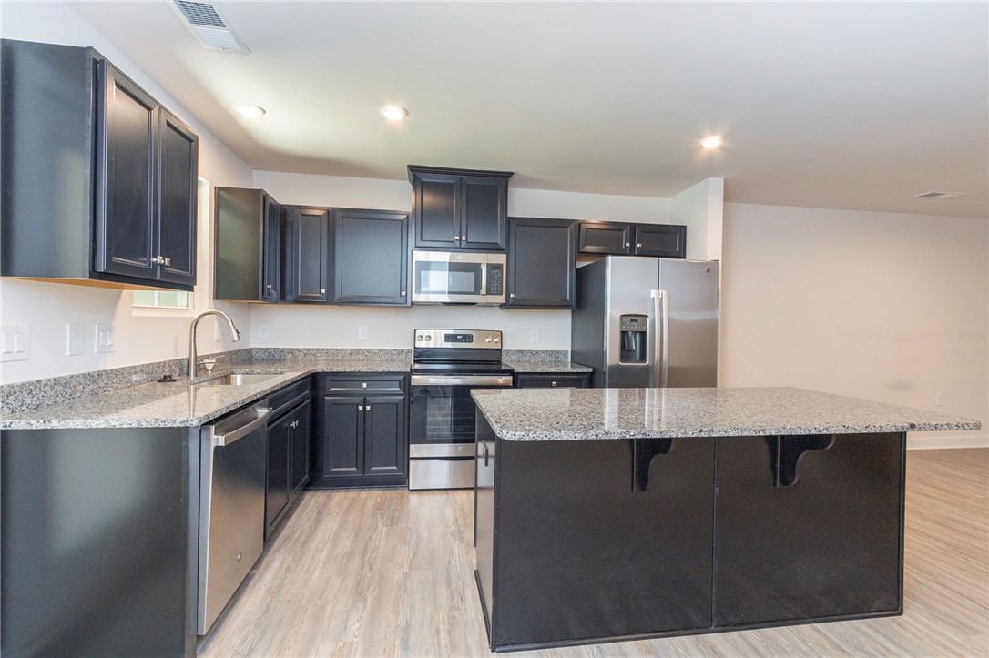 233 Scenic Road Anderson, SC 29621 - Photo 15 of 50 Culinary delights await in this modern kitchen, featuring sleek dark cabinetry and granite countertops.