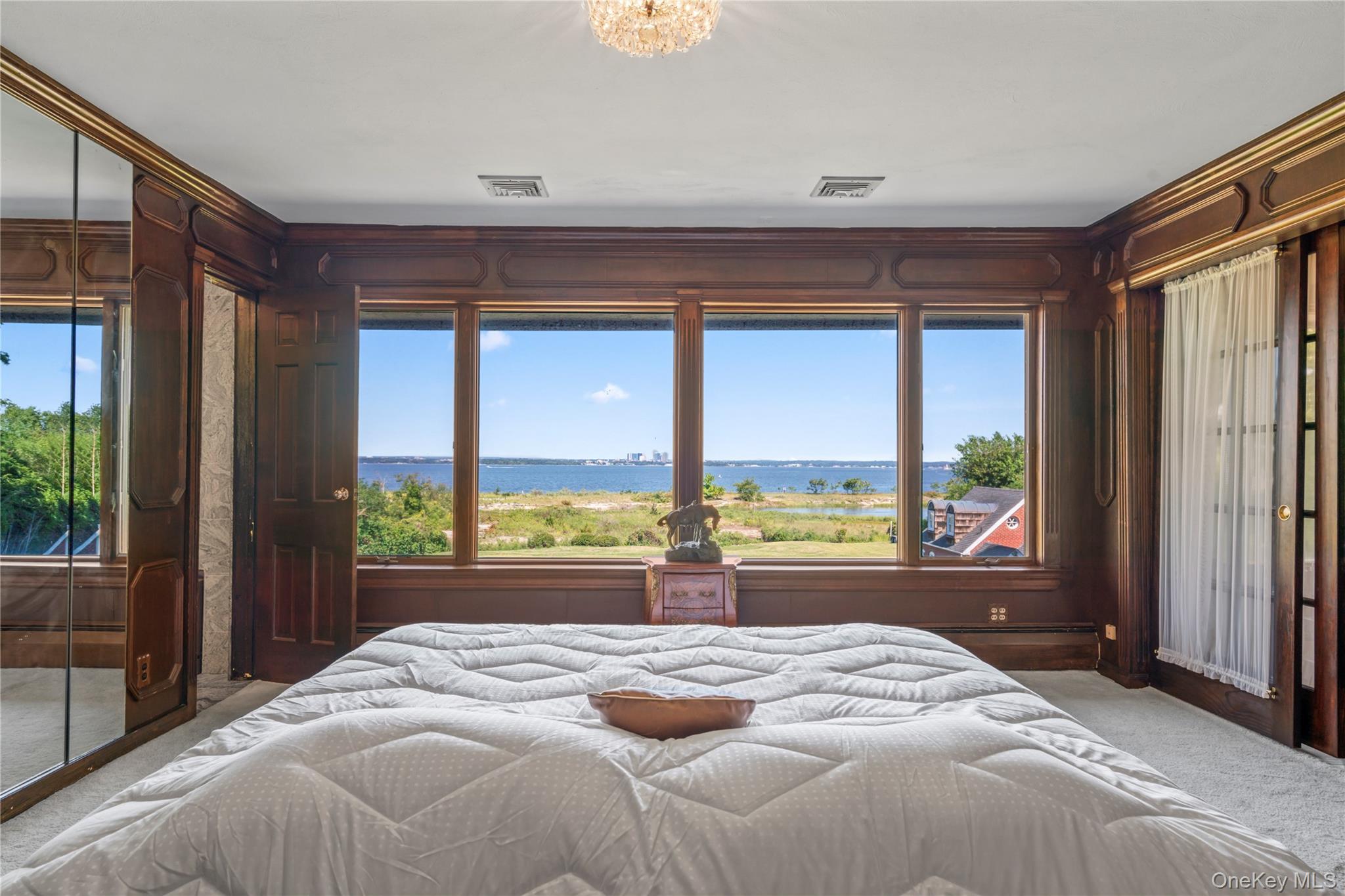 22 Messenger Lane Sands Point, NY 11050 - Photo 22 of 49 a bedroom with a large bed and a large window