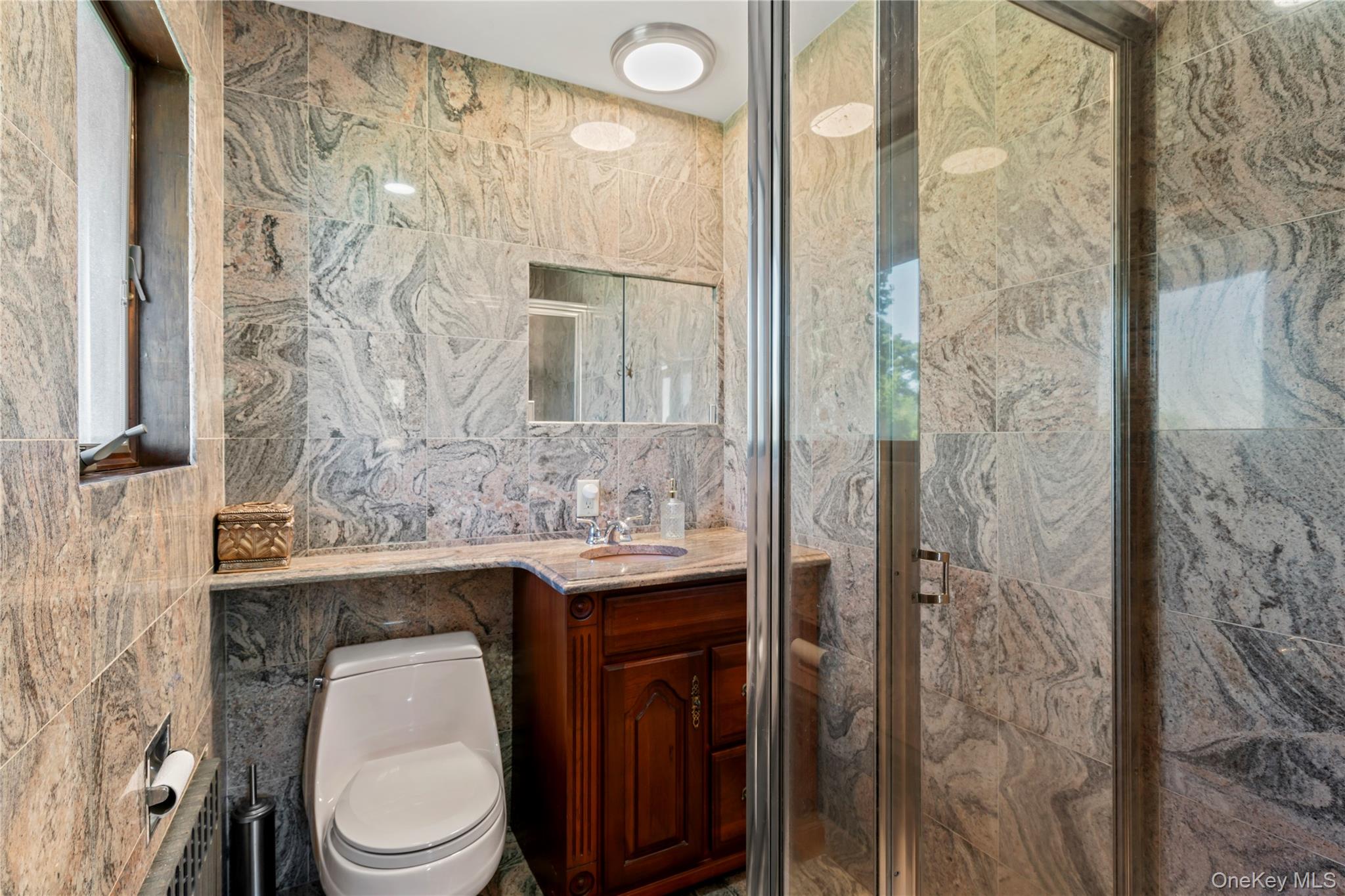 22 Messenger Lane Sands Point, NY 11050 - Photo 31 of 49 a bathroom with a toilet a sink and a shower curtain