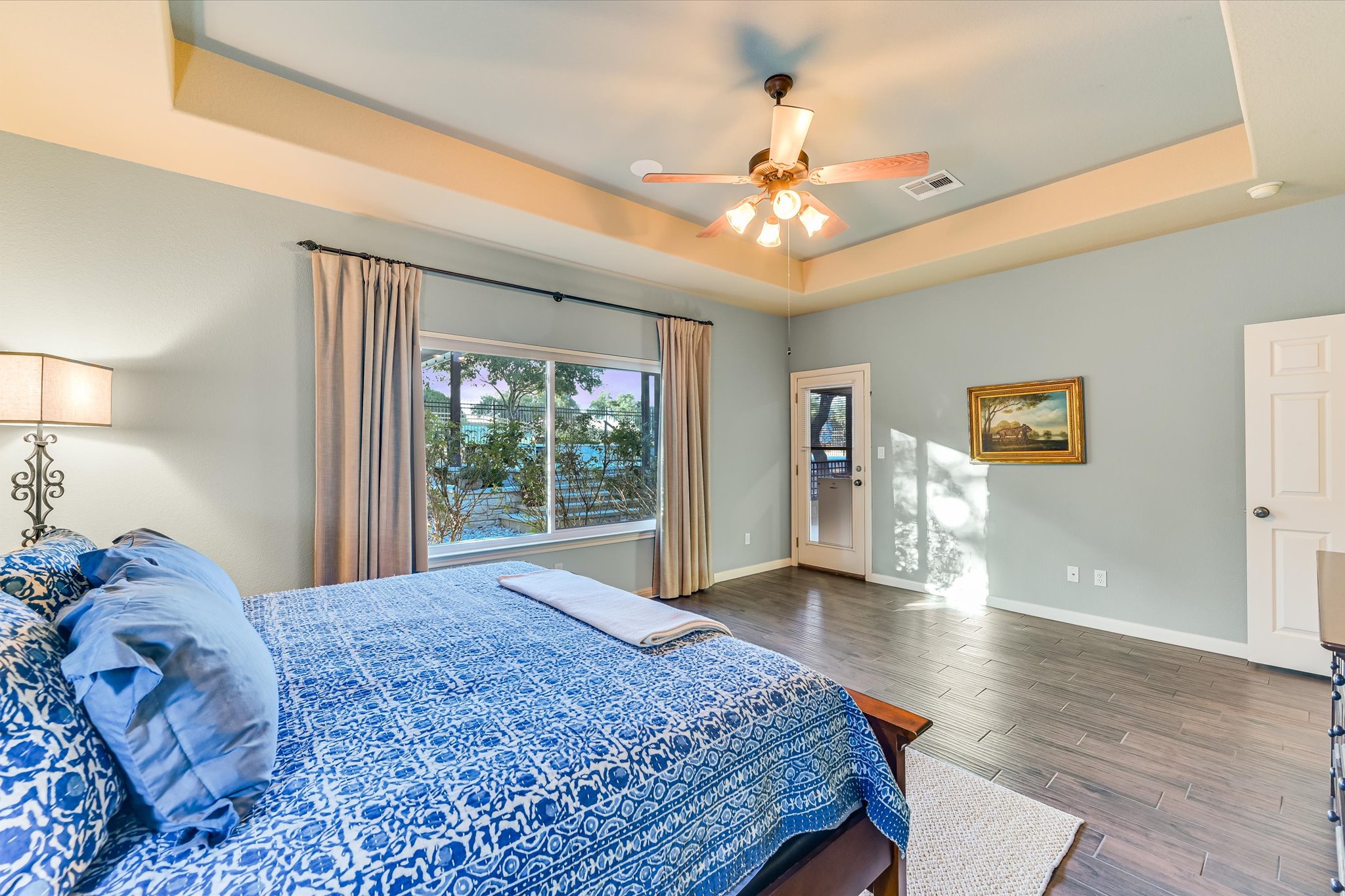 786 Ranchers Club Lane Driftwood, TX 78619 - Photo 17 of 33 Bedroom featuring a tray ceiling, a ceiling fan, and dark wood-style floors