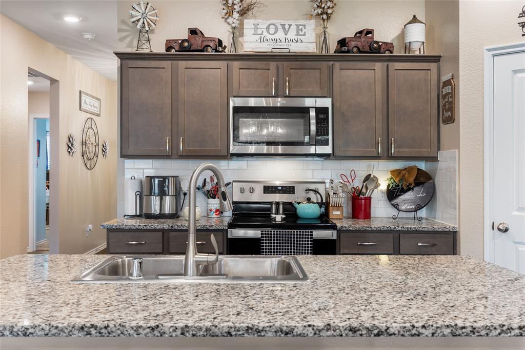 173 Seabiscuit Road Caddo Mills, TX 75135 - Photo 12 of 40 a kitchen with stainless steel appliances granite countertop a stove and cabinets