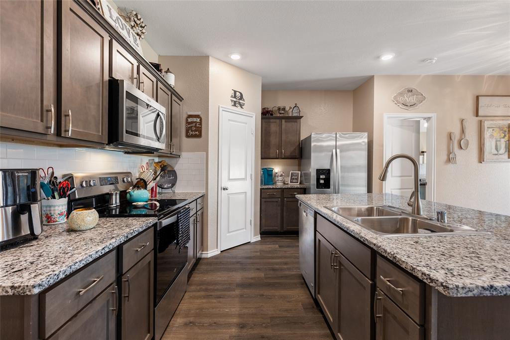 173 Seabiscuit Road Caddo Mills, TX 75135 - Photo 13 of 40 a kitchen with stainless steel appliances granite countertop a sink stove and refrigerator