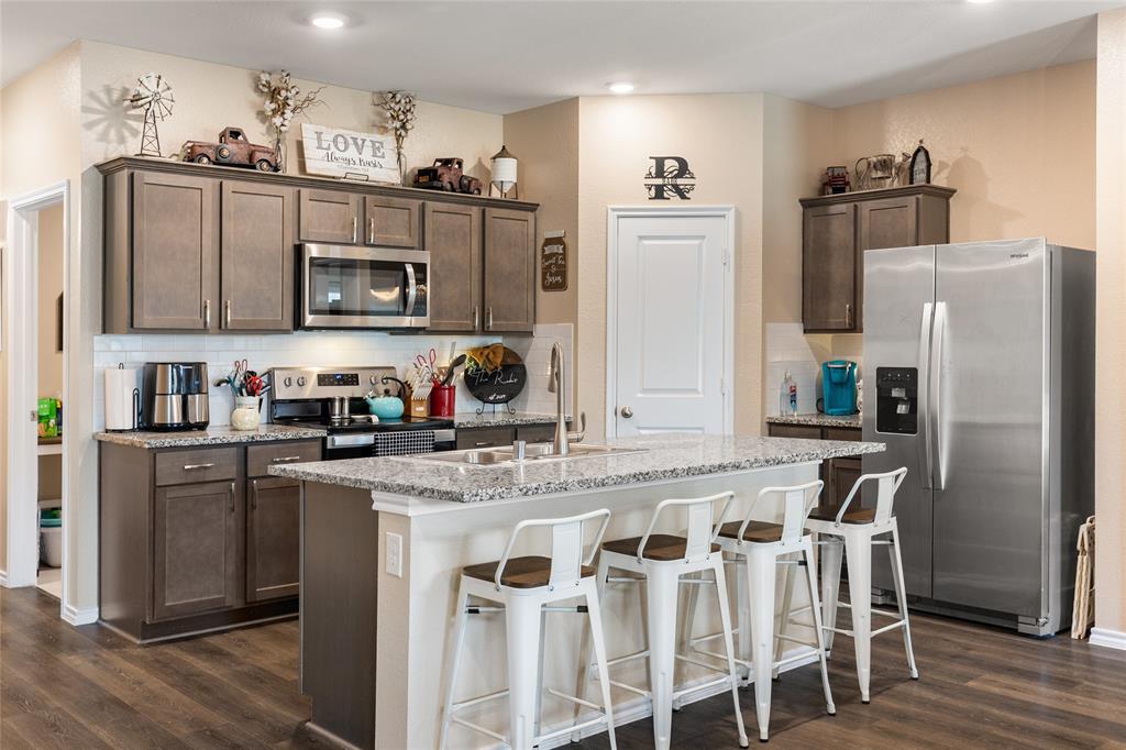 173 Seabiscuit Road Caddo Mills, TX 75135 - Photo 9 of 40 a kitchen with stainless steel appliances granite countertop a refrigerator and a stove top oven