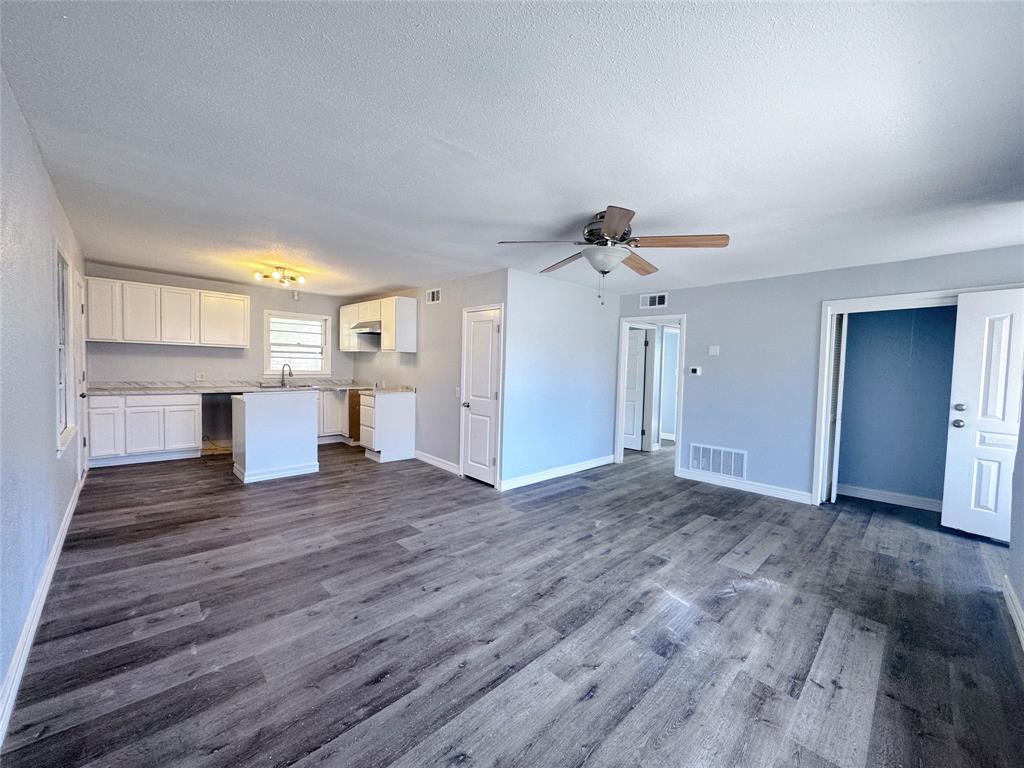 345 16th Street Southwest Paris, TX 75460 - Photo 4 of 15 a view of a kitchen with wooden floor and a ceiling fan