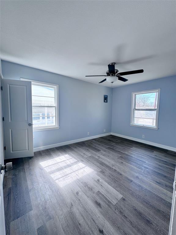 345 16th Street Southwest Paris, TX 75460 - Photo 10 of 15 an empty room with wooden floor ceiling fan and windows