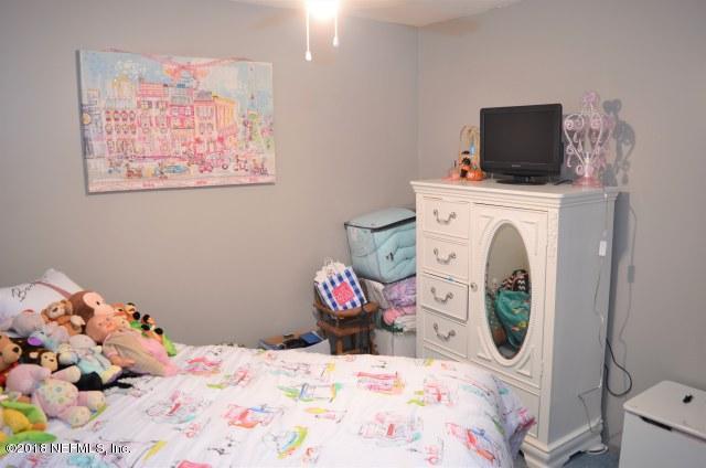 54170 Vontz Road East Callahan, FL 32011 - Photo 12 of 24 a bedroom with a bed and a flat screen tv
