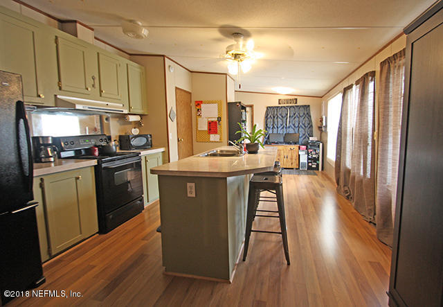 54170 Vontz Road East Callahan, FL 32011 - Photo 2 of 24 a kitchen with sink a refrigerator and wooden floor