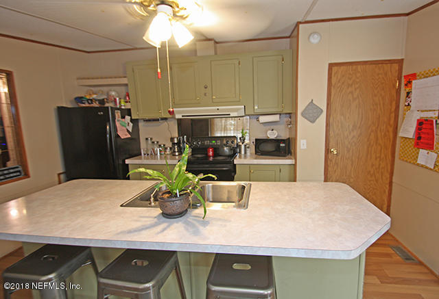 54170 Vontz Road East Callahan, FL 32011 - Photo 3 of 24 a kitchen with stainless steel appliances a dining table and chairs