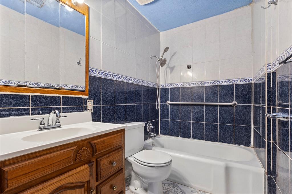 2821 Burchill Road South Fort Worth, TX 76105 - Photo 19 of 33 Bathroom with tile walls, shower combination, vanity, and decorative backsplash