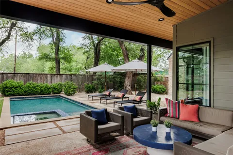 a living room with patio furniture and a floor to ceiling window