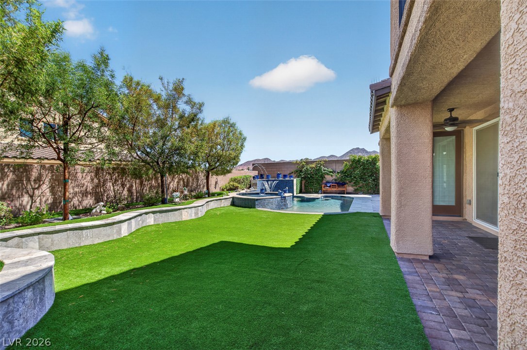 1824 Redland Ridge Street Henderson, NV 89002 - Photo 64 of 69 A private backyard oasis features lush artificial turf, a sparkling pool, and mountain views.