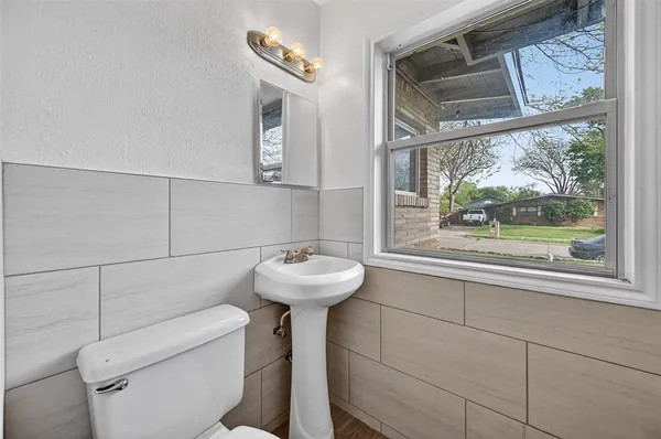 a bathroom with a sink a toilet and a mirror