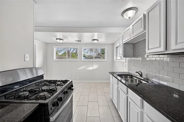 a kitchen with stainless steel appliances granite countertop a stove and a sink