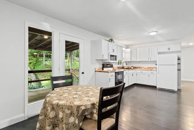 a kitchen with a table chairs refrigerator and cabinets