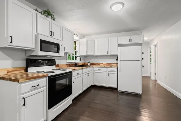 a kitchen with cabinets stainless steel appliances and wooden floor