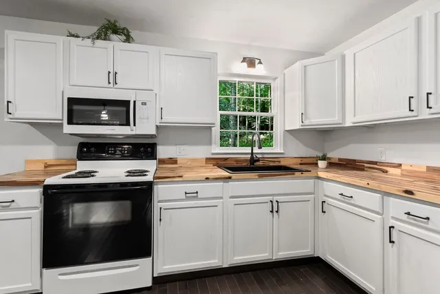 a kitchen with cabinets stainless steel appliances a sink and a window
