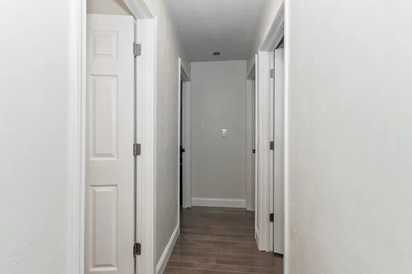 a view of a hallway with wooden floor