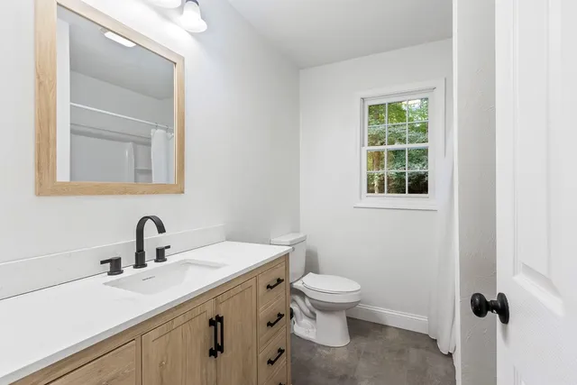 a bathroom with a toilet sink and mirror