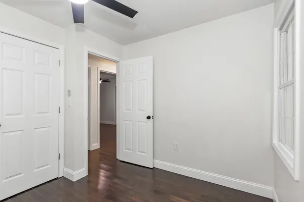 an empty room with wooden floor and sink