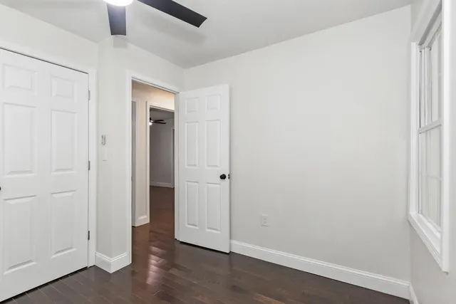an empty room with wooden floor and sink