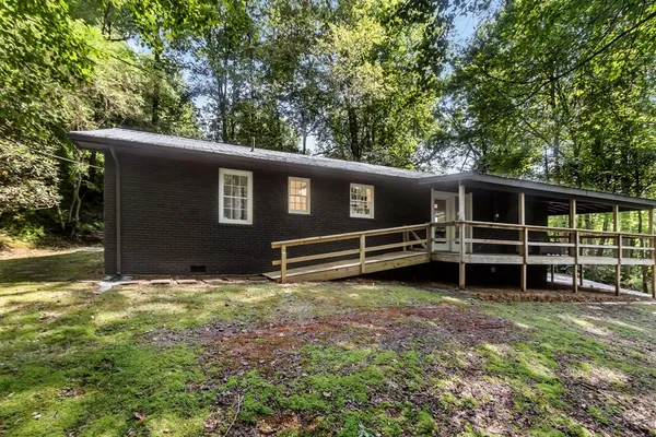 a view of a house with a yard and wooden fence