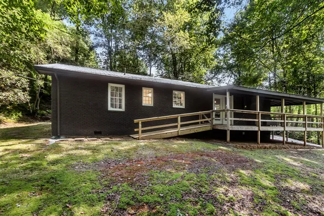 a view of a house with a yard and wooden fence
