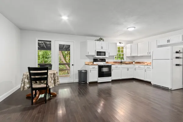 a kitchen with white cabinets and white appliances