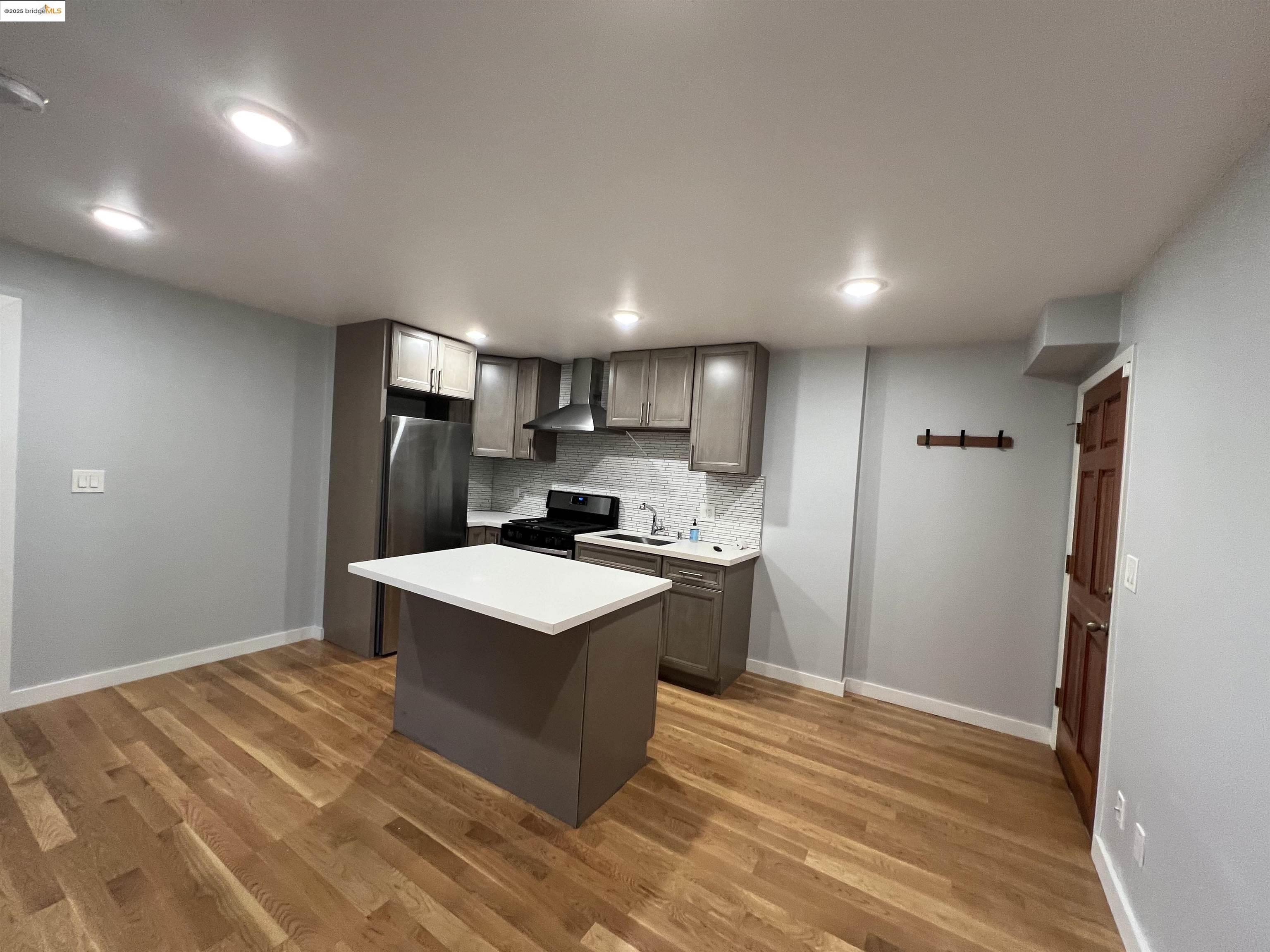 a kitchen with a refrigerator a sink and a stove top oven