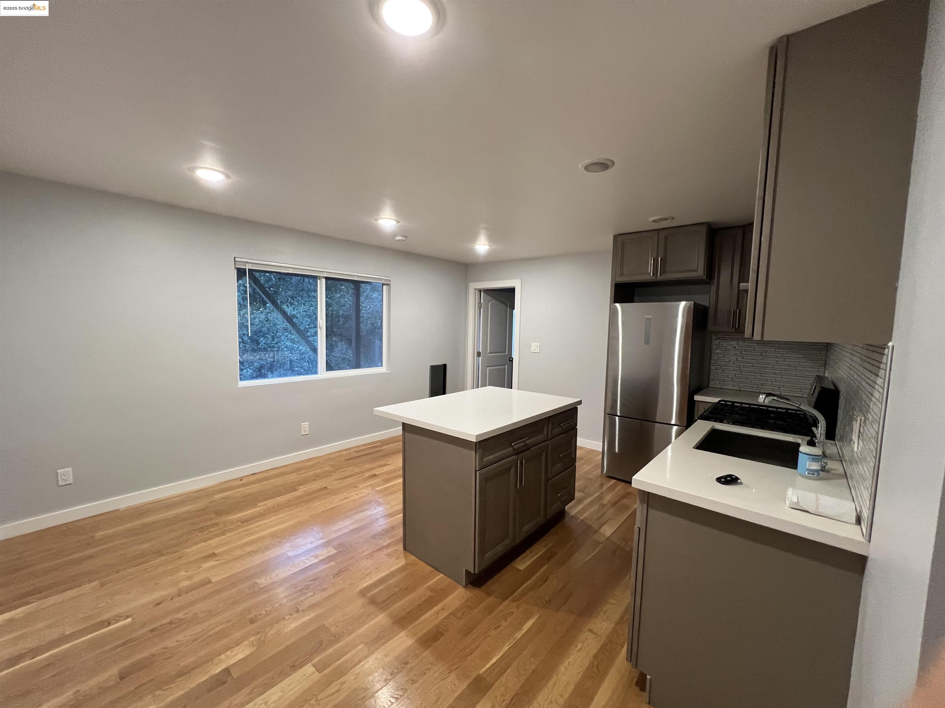 900 Everett Avenue, Unit A Oakland, CA 94602 - Photo 2 of 10 a kitchen with kitchen island white cabinets and refrigerator