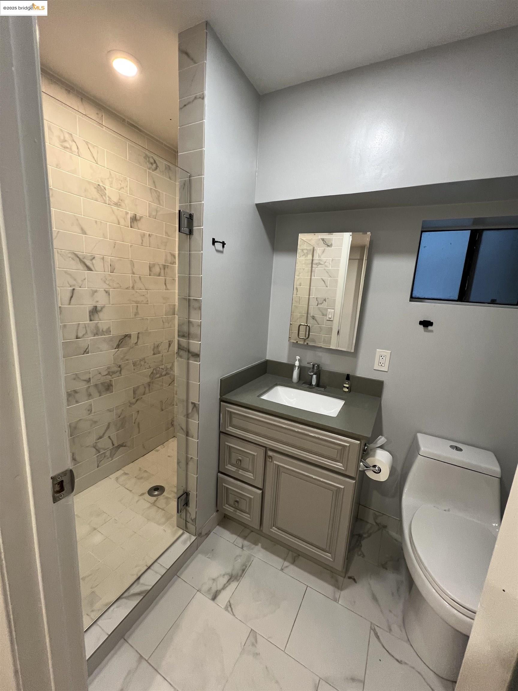 900 Everett Avenue, Unit A Oakland, CA 94602 - Photo 4 of 10 a bathroom with a granite countertop sink a toilet and shower