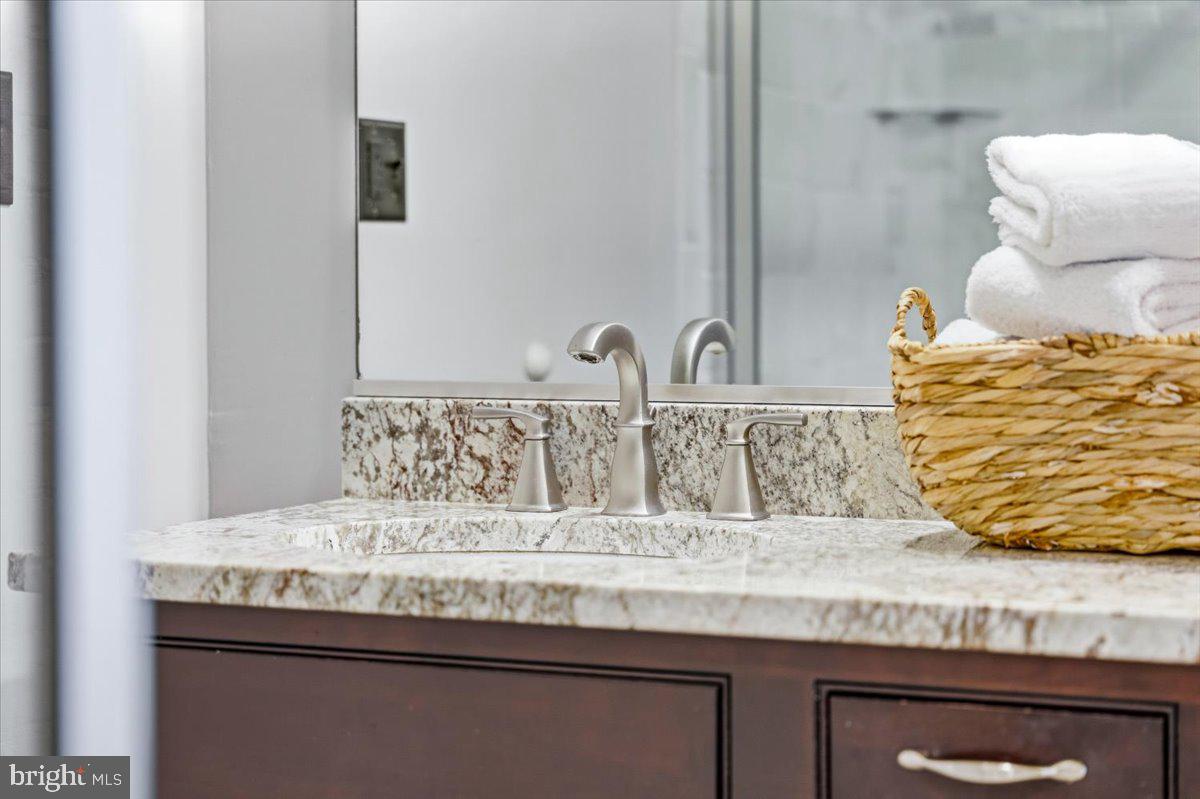 37 East 5th Street Frederick, MD 21701 - Photo 29 of 50 a bathroom with a granite countertop sink and a mirror