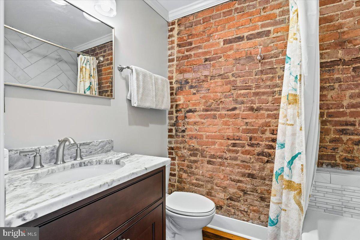37 East 5th Street Frederick, MD 21701 - Photo 36 of 50 a bathroom with a granite countertop toilet a sink and a mirror