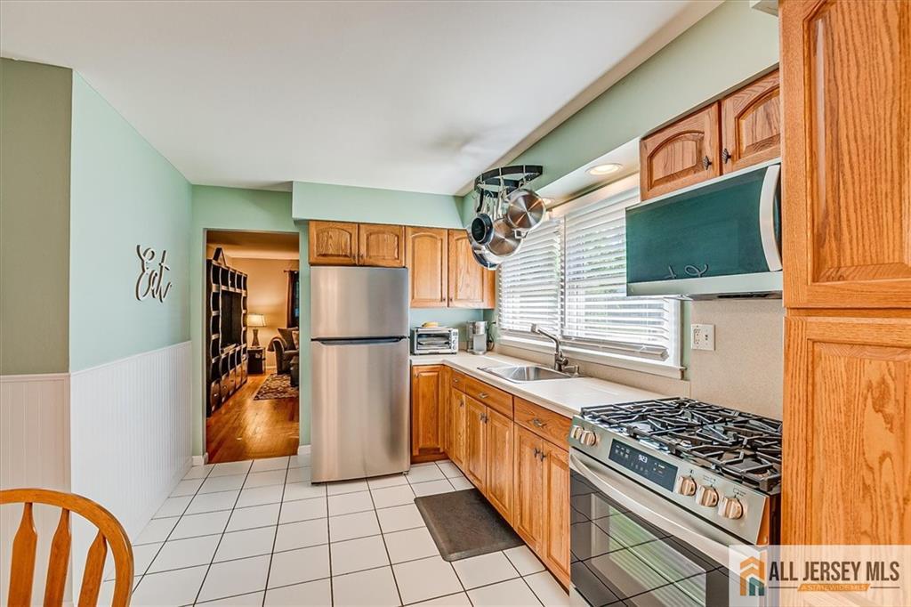 20 Melville Road Edison, NJ 08817 - Photo 12 of 31 a kitchen with a refrigerator and a stove top oven