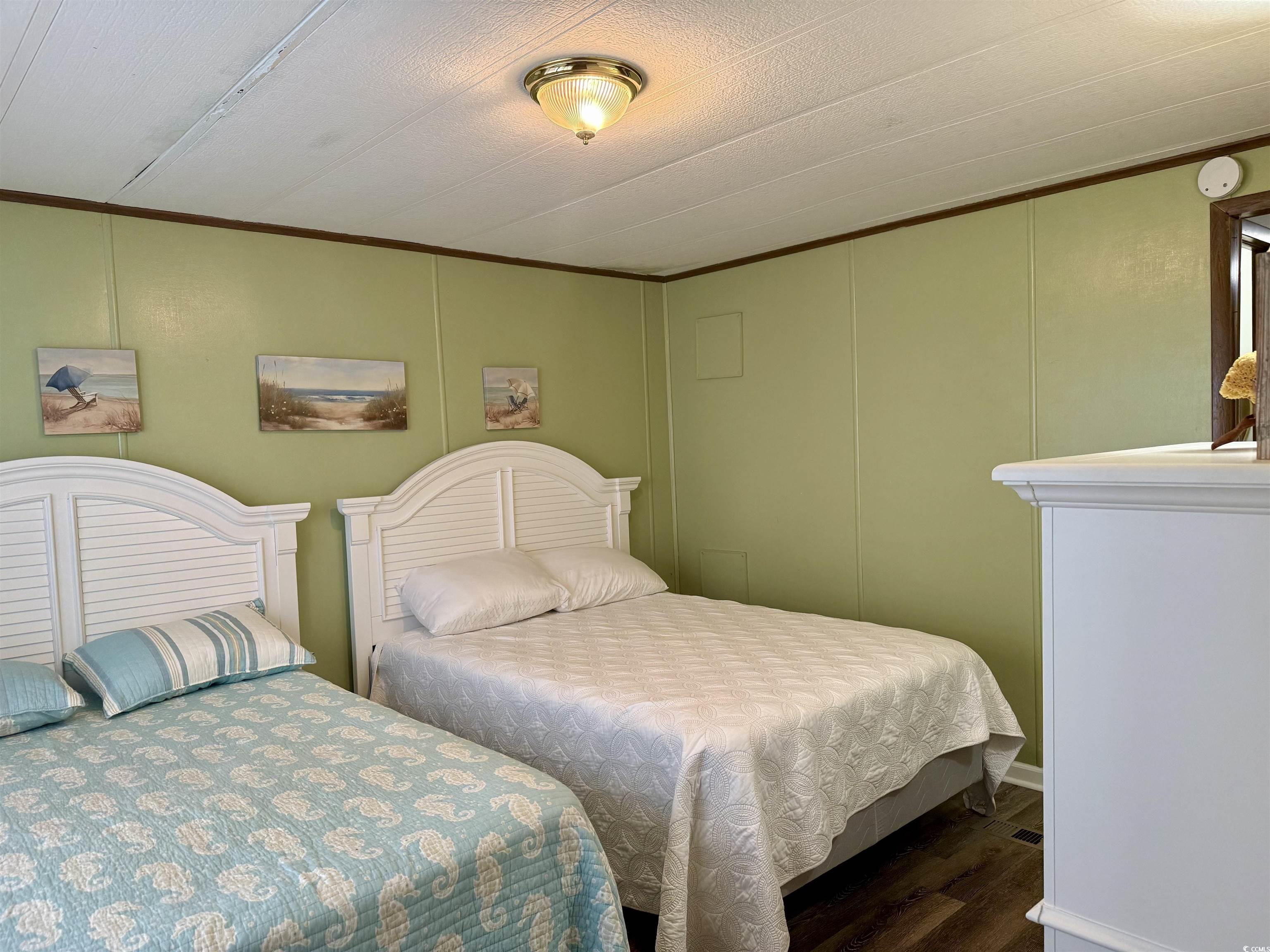 1801 E Lake Surfside Beach, SC 29575 - Photo 19 of 32 Bedroom featuring a decorative wall, wood finished floors, and ornamental molding