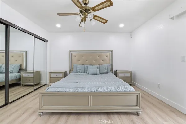 a bedroom with a bed and glass walk in closet