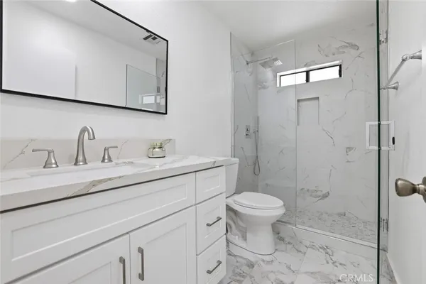 a bathroom with a sink a toilet and shower