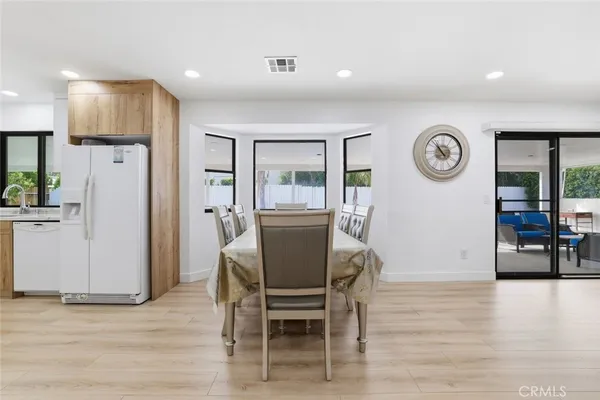 a view of a dining room with furniture and a kitchen view
