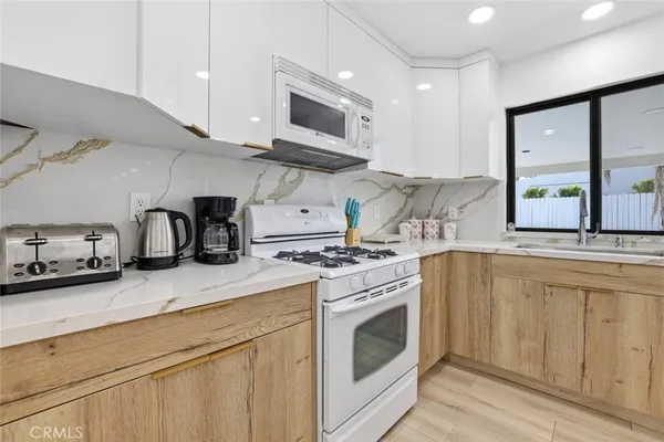 a kitchen with stainless steel appliances granite countertop a stove a sink and a microwave