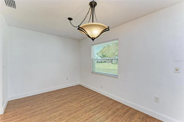 a view of a room with wooden floor and chandelier