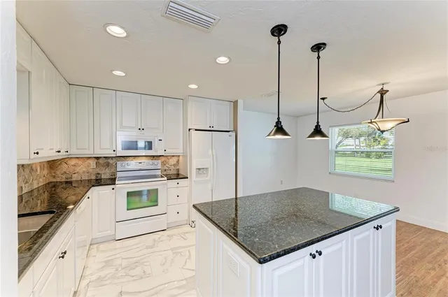 a kitchen with kitchen island a counter top space appliances and cabinets