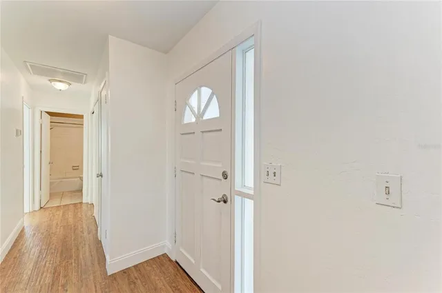 a view of a hallway with wooden floor