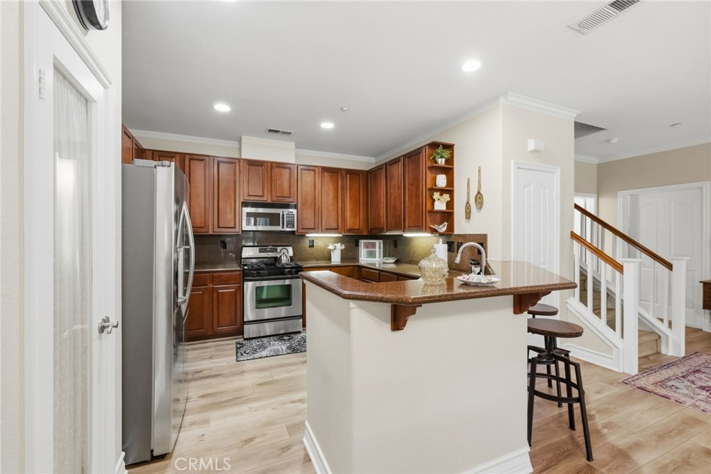 7331 Shelby Place, Unit 84 Rancho Cucamonga, CA 91739 - Photo 11 of 43 a kitchen with kitchen island a stove a sink and a refrigerator