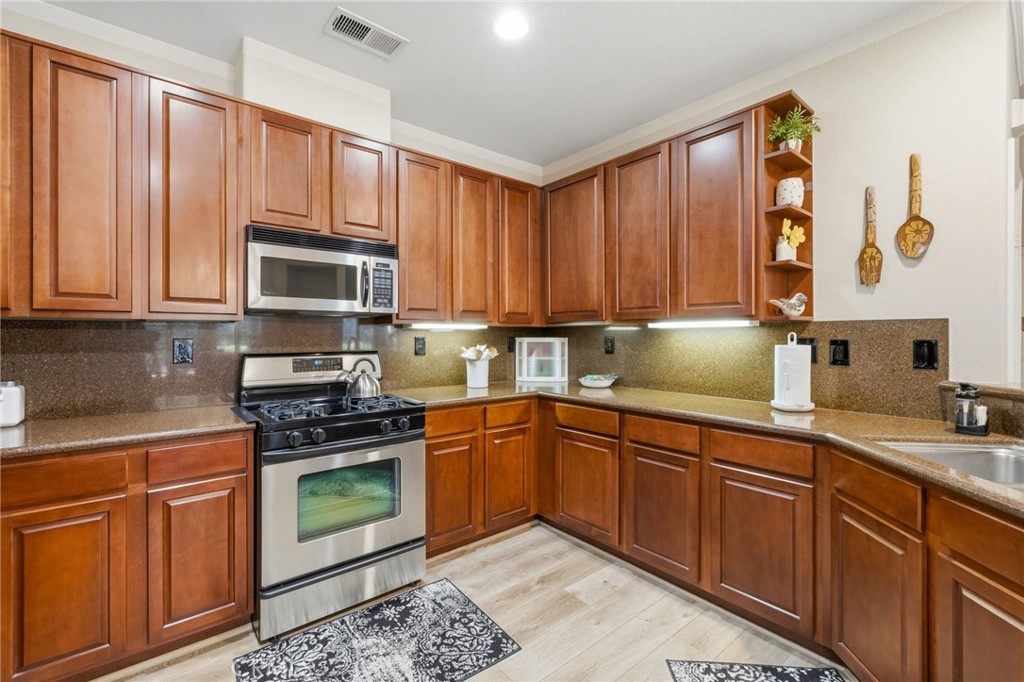 7331 Shelby Place, Unit 84 Rancho Cucamonga, CA 91739 - Photo 12 of 43 a kitchen with stainless steel appliances granite countertop a stove sink microwave and cabinets
