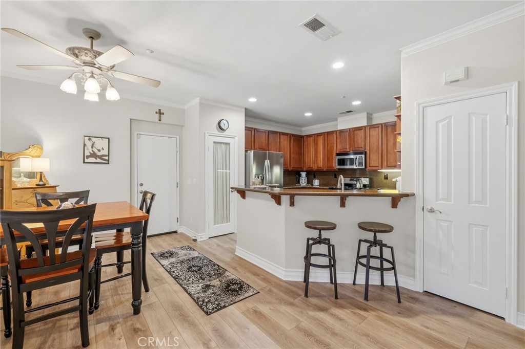 7331 Shelby Place, Unit 84 Rancho Cucamonga, CA 91739 - Photo 9 of 43 a kitchen with stainless steel appliances kitchen island granite countertop a dining table chairs and granite counter tops