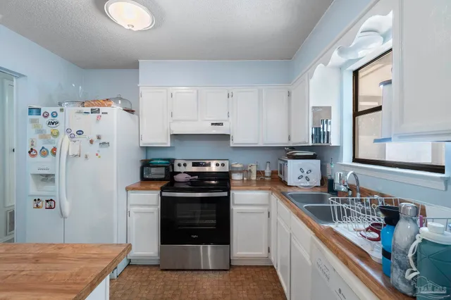 a kitchen with stainless steel appliances granite countertop a refrigerator sink and stove