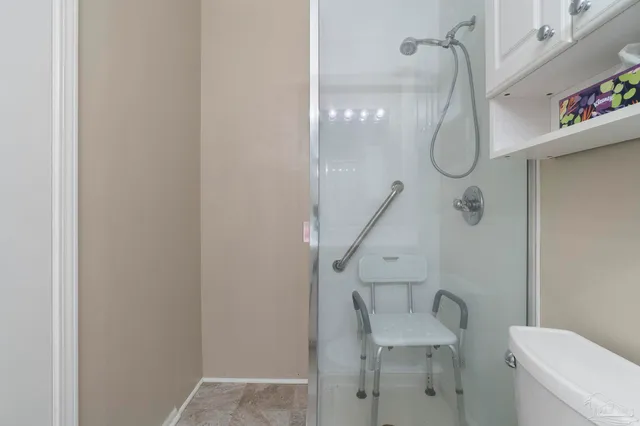 a bathroom with a toilet and a shower