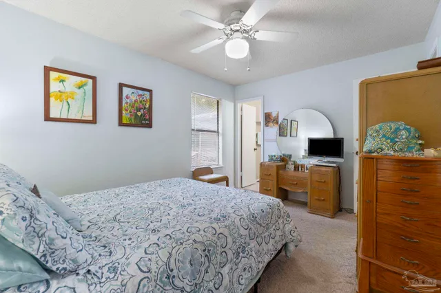 a bedroom with a bed dresser and window