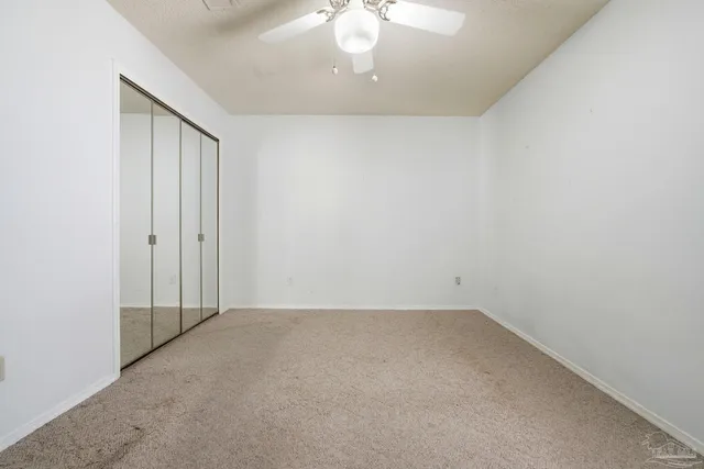 an empty room with fan and entrance