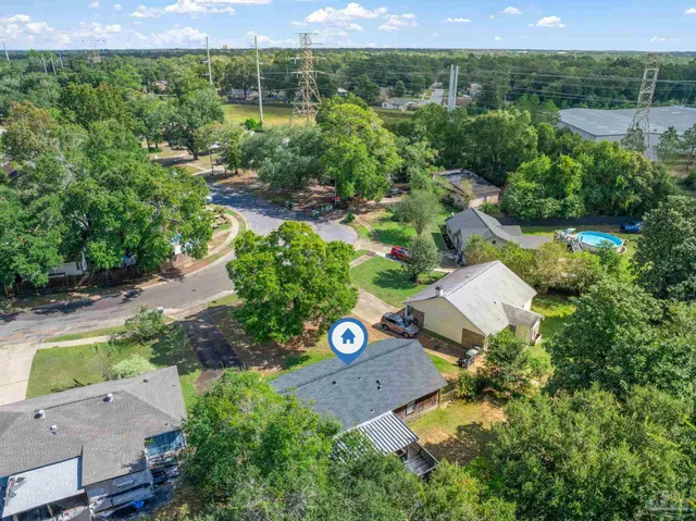 an aerial view of a house with a yard and outdoor seating