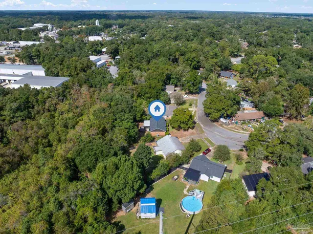 an aerial view of residential houses with outdoor space and trees